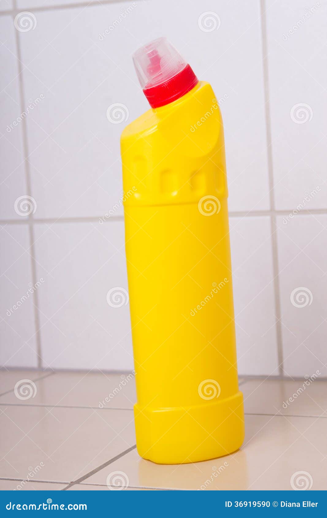 Yellow Plastic Bottle of Cleaning Product on Tiled Floor Stock Photo