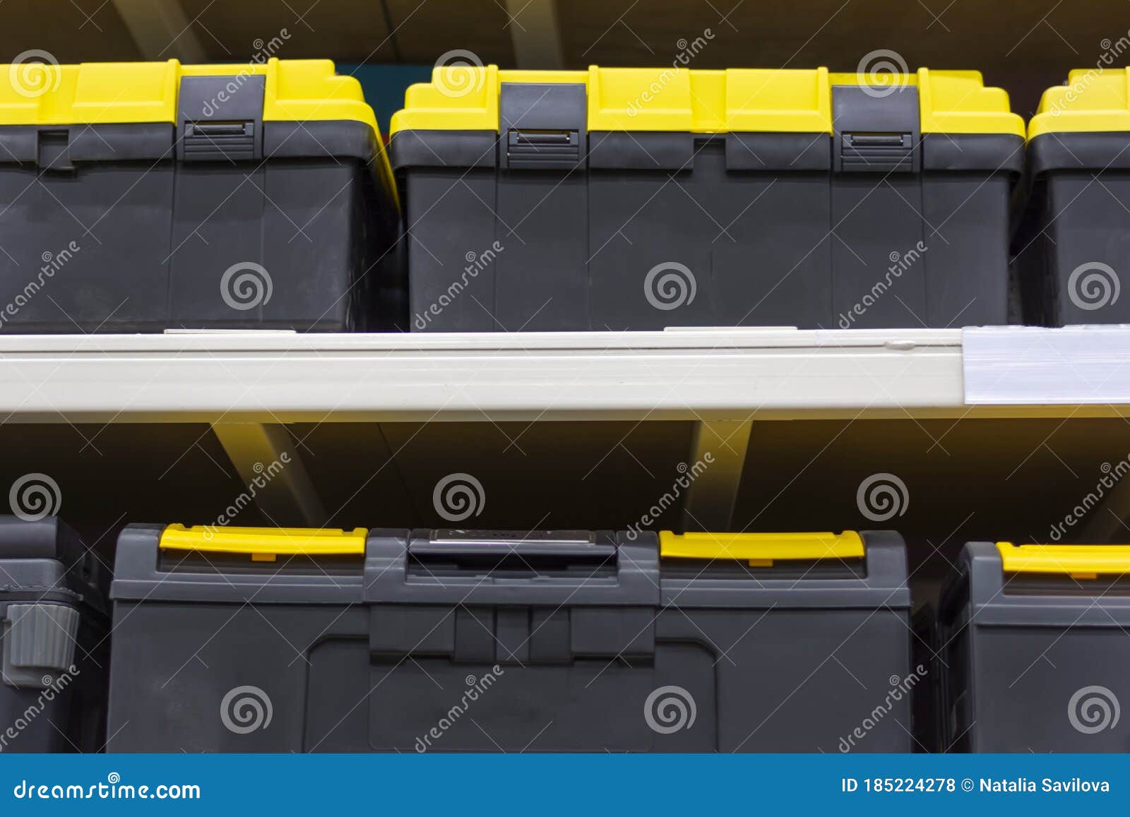 Yellow Plastic Tool Boxes on a Shelf in a Hardware Store. Stock Photo