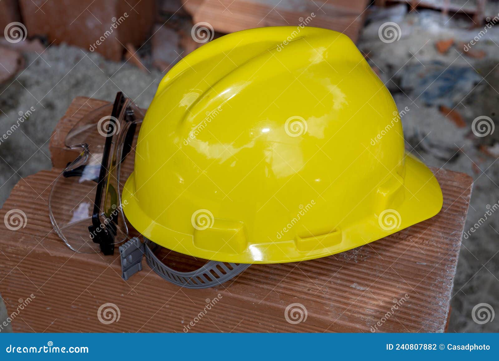 yellow protective helmet on pile of red bricks