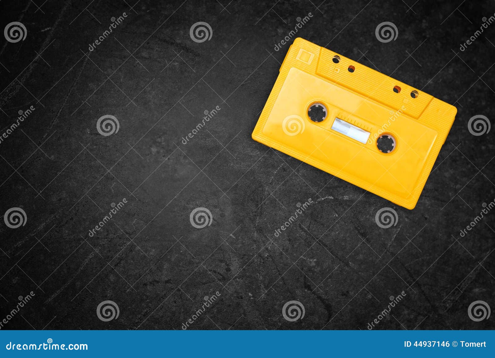 Yellow Retro Cassette Tape Over Blackboard. Top View Stock Photo