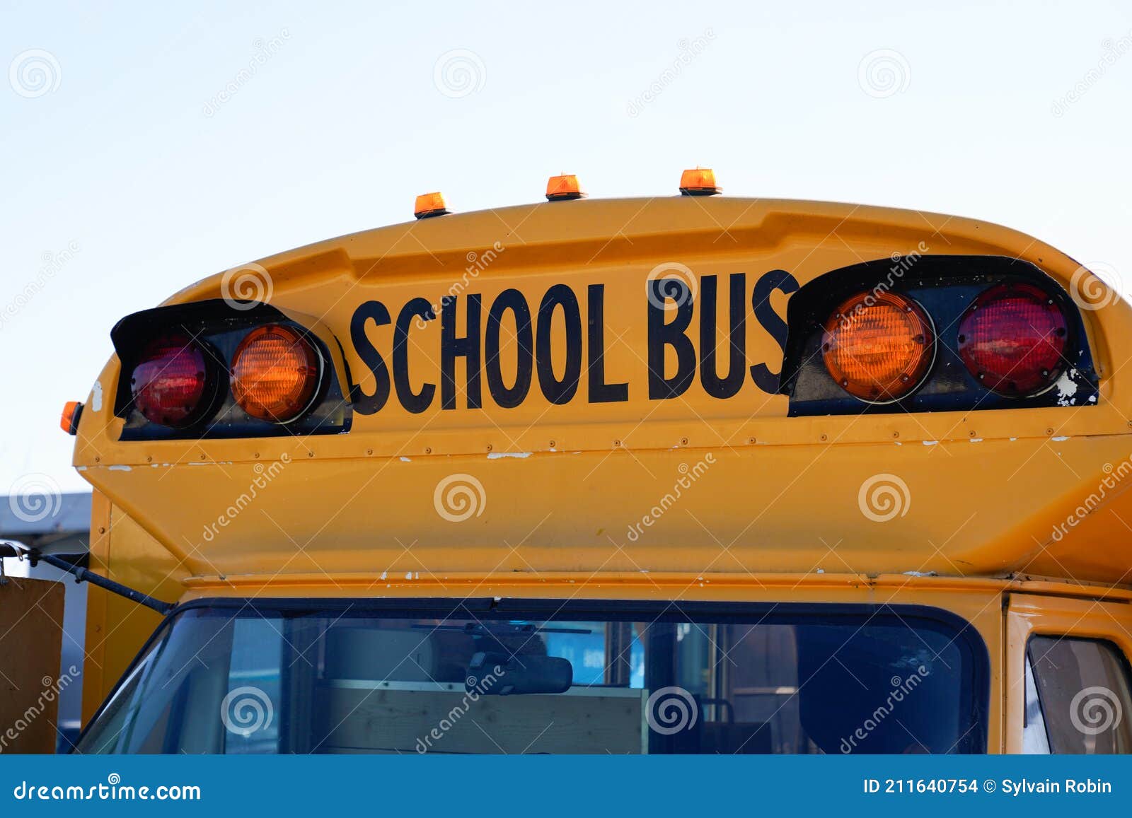 Yellow School Bus Front View with Text Sign and Security Light Stock