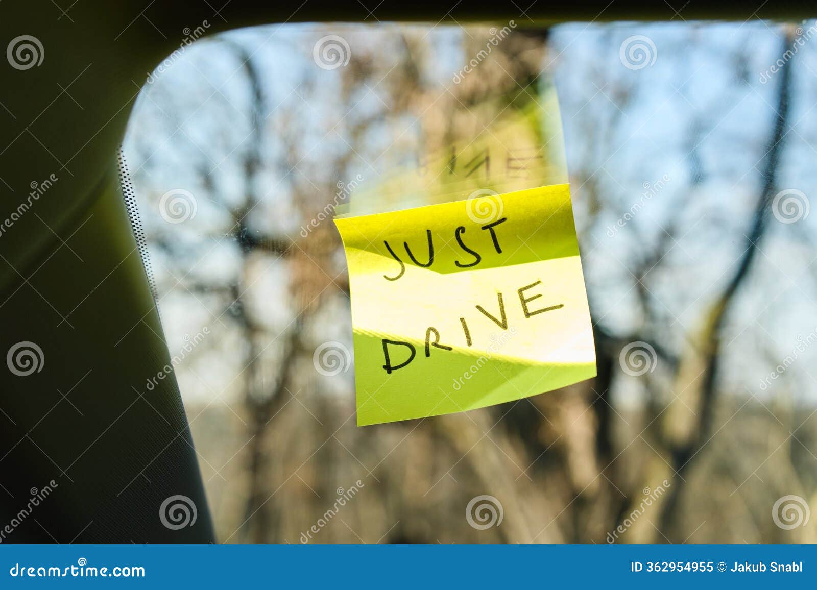 sticky note with 'just drive' on car window