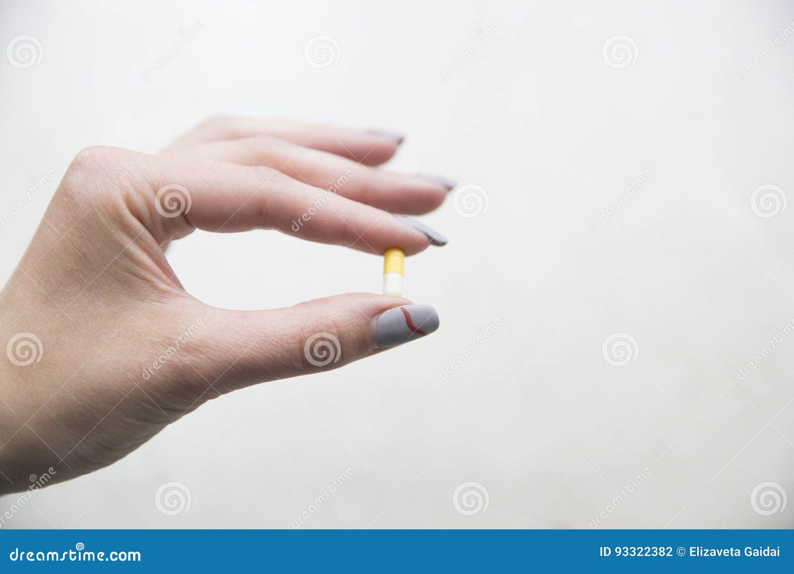 Yellow and White Capsule in a Female Hand Stock Photo Image of