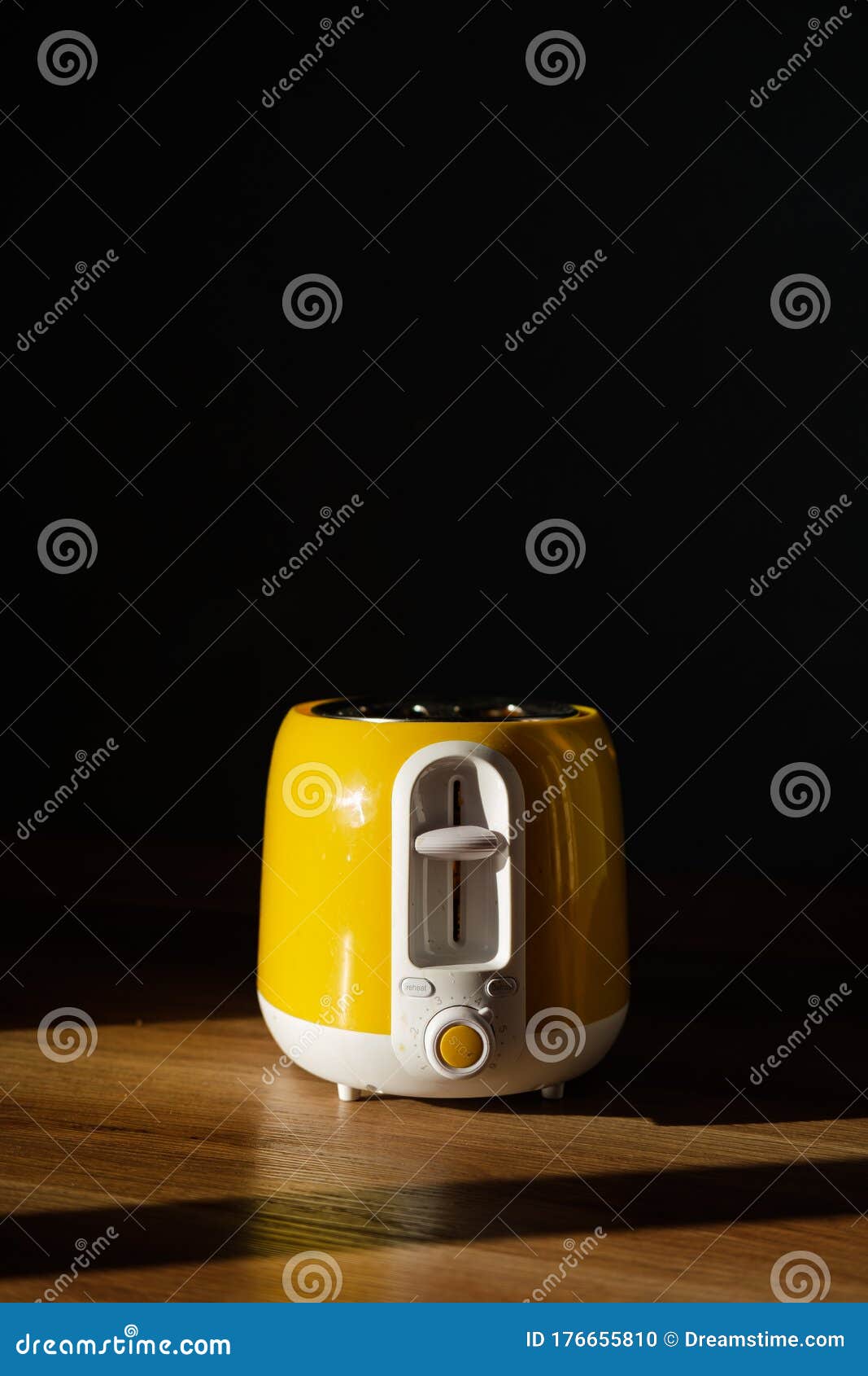 Yellow and white plastic toaster with stainless steel top. Yellow toaster kitchen utensil with stainless steel top
