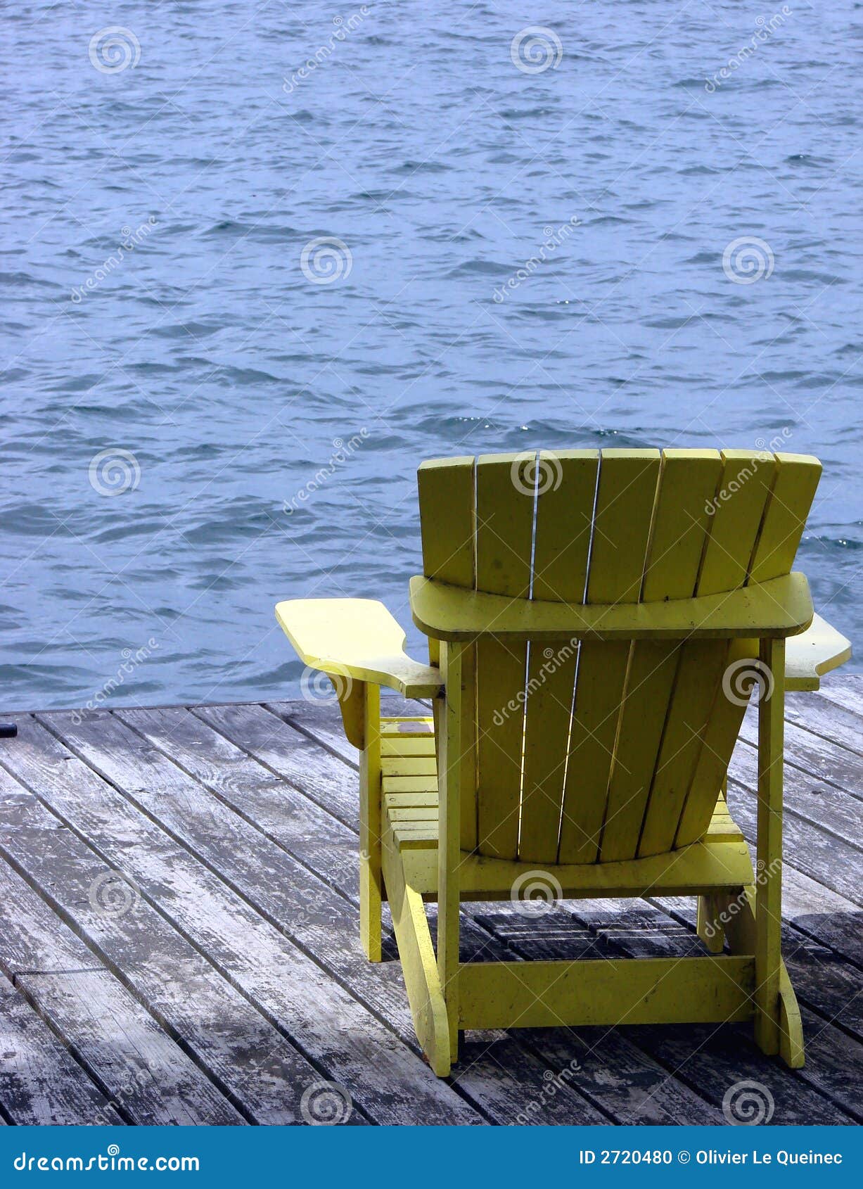 Yellow Wood Adirondack Chair On A Dock Over Water Stock 