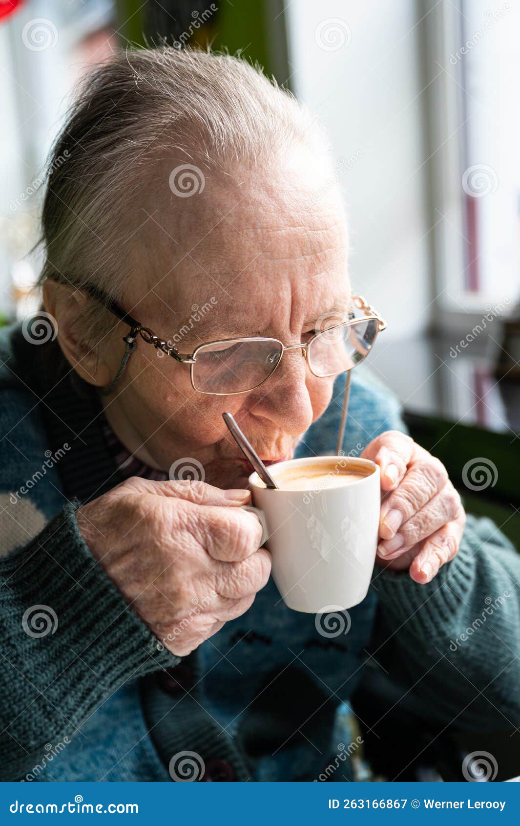 84 yo white woman drinking a cup of coffee, tienen, belgium