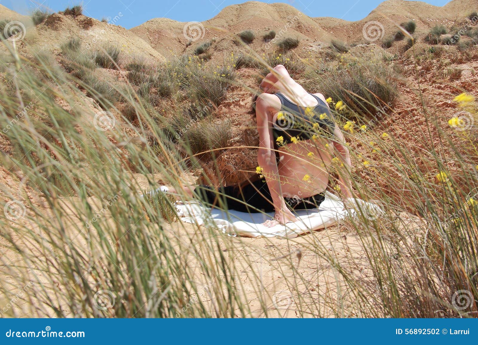 Donna che fa yoga nel deserto