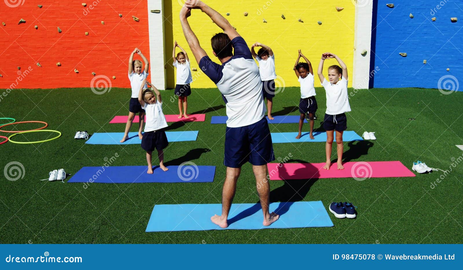 Yoga Instructor Instructing Children in Performing Exercise Stock