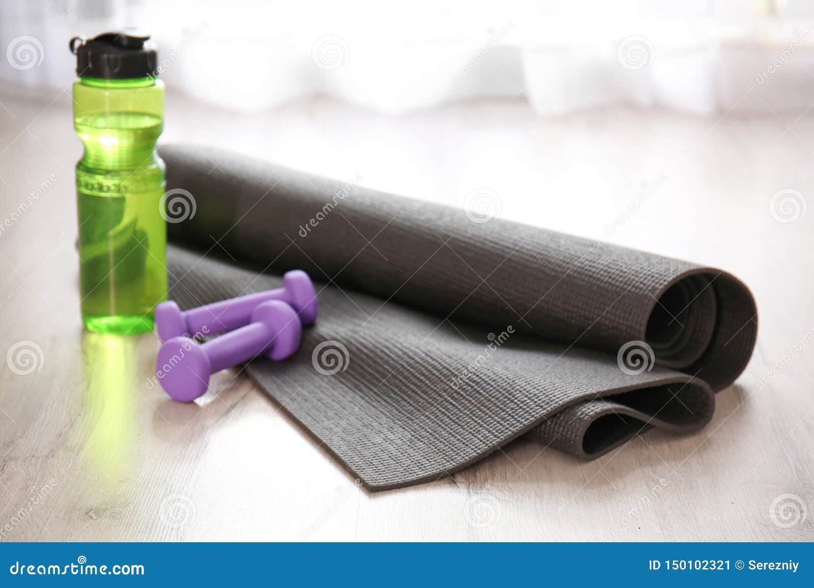 Yoga Mat with Bottle of Water and Dumbbells on Wooden Floor Stock Image ...