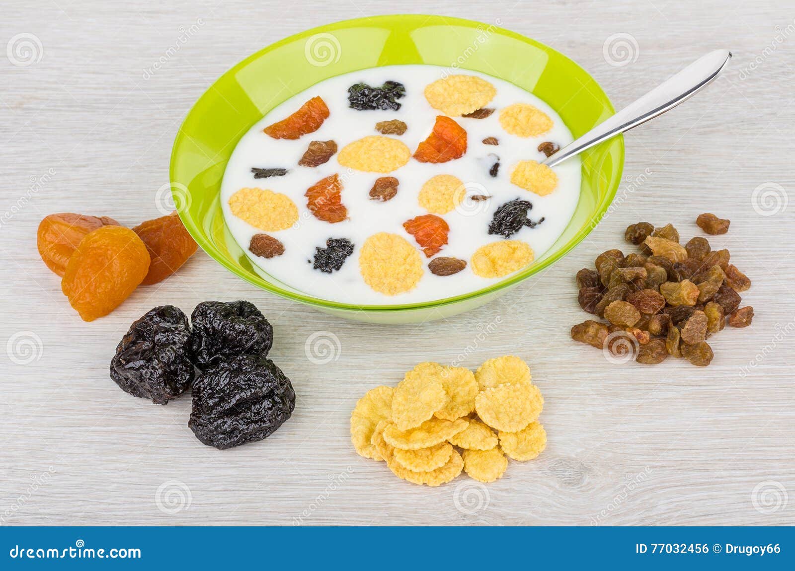 Yogurt with Corn Flakes and Dried Fruit in Green Bowl Stock Photo
