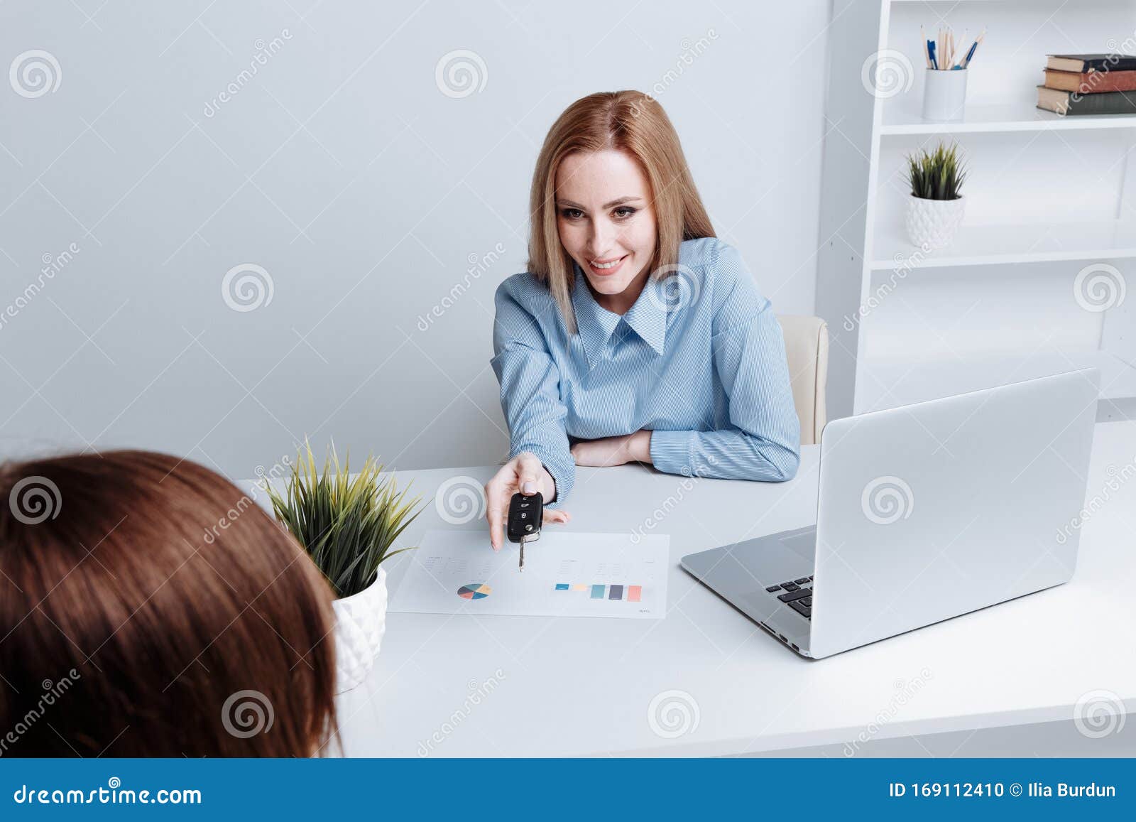 yong pretty woman holding keys and giving it to the customer. contract of buing a car.