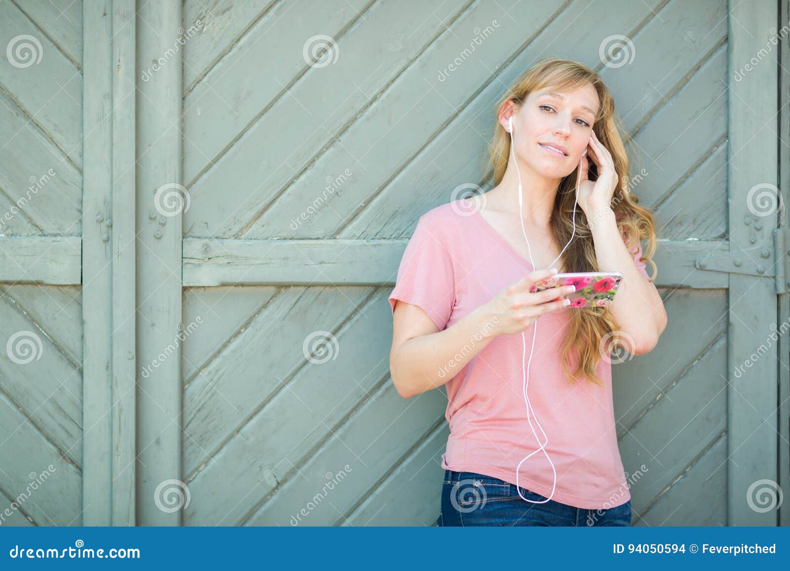 Young Adult Brown Eyed Teen Girl Listens To Music on Her Smart Phone.