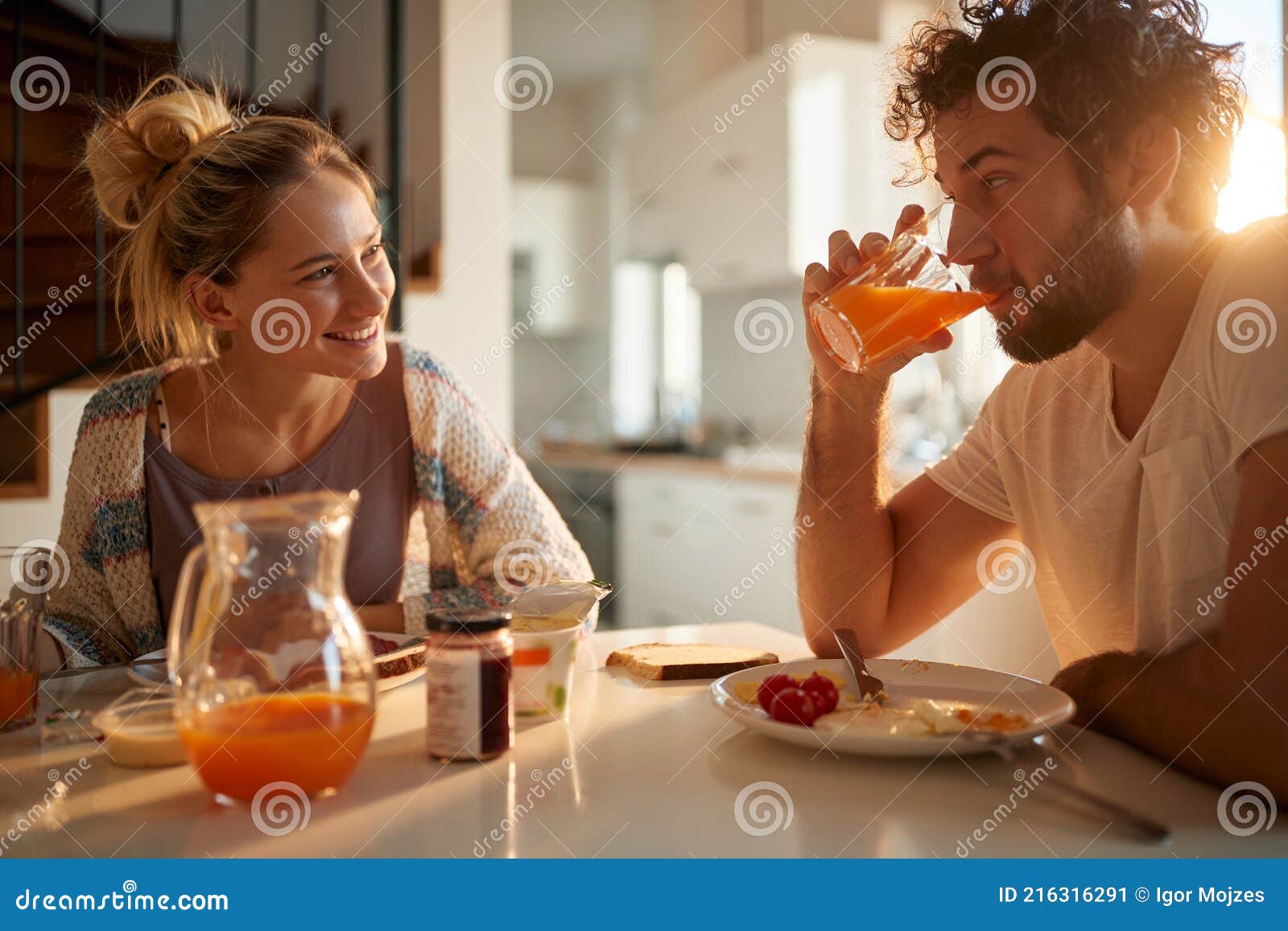 young-adult-caucasian-couple-having-breakfast-sunny-dining-room-looking-each-other-smiling-216316291.jpg