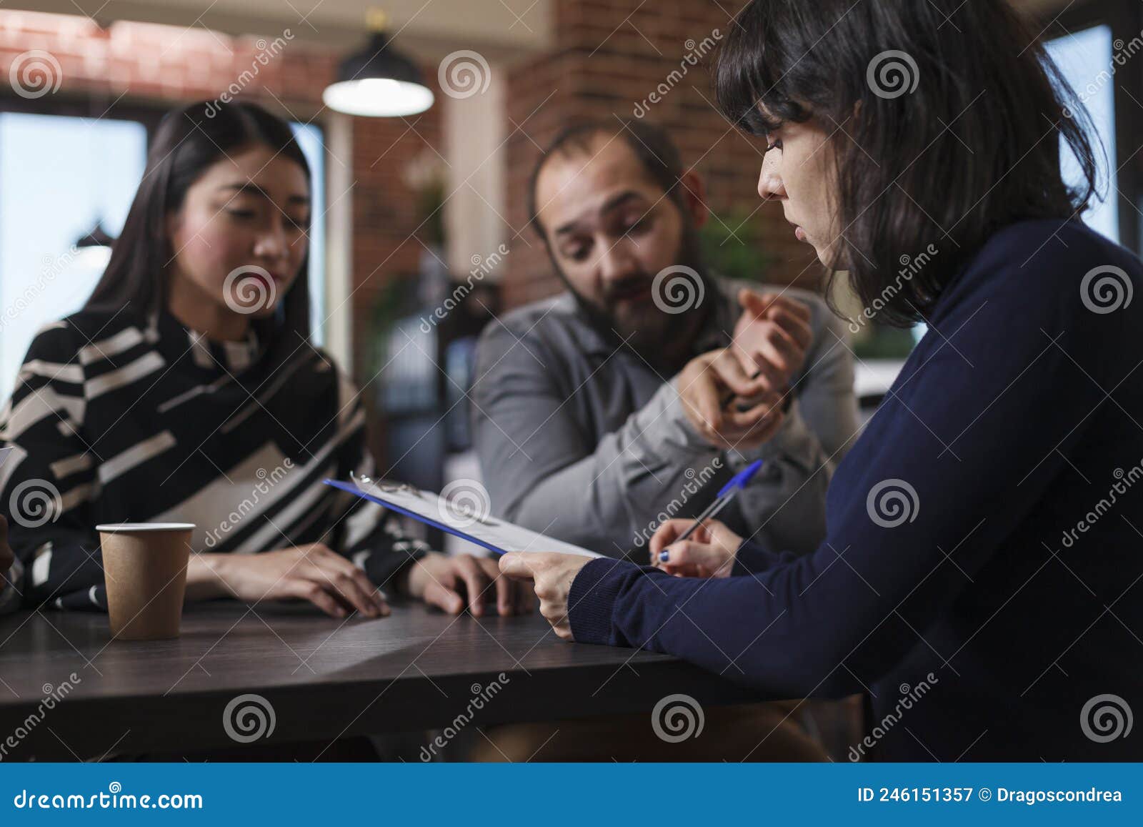 young adult recruiter sitting at desk in office space while reviewing job applicants cvs.