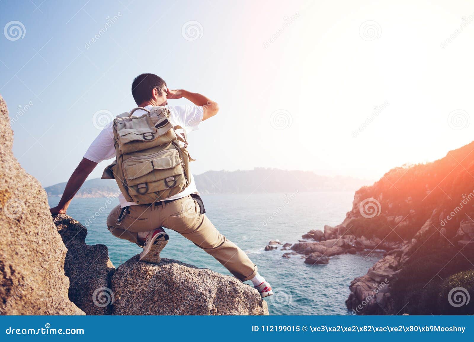 Tage af træ eskortere Young Adventure Man Sitting on the Rocks Above the Ocean Stock Image -  Image of travel, adventure: 112199015