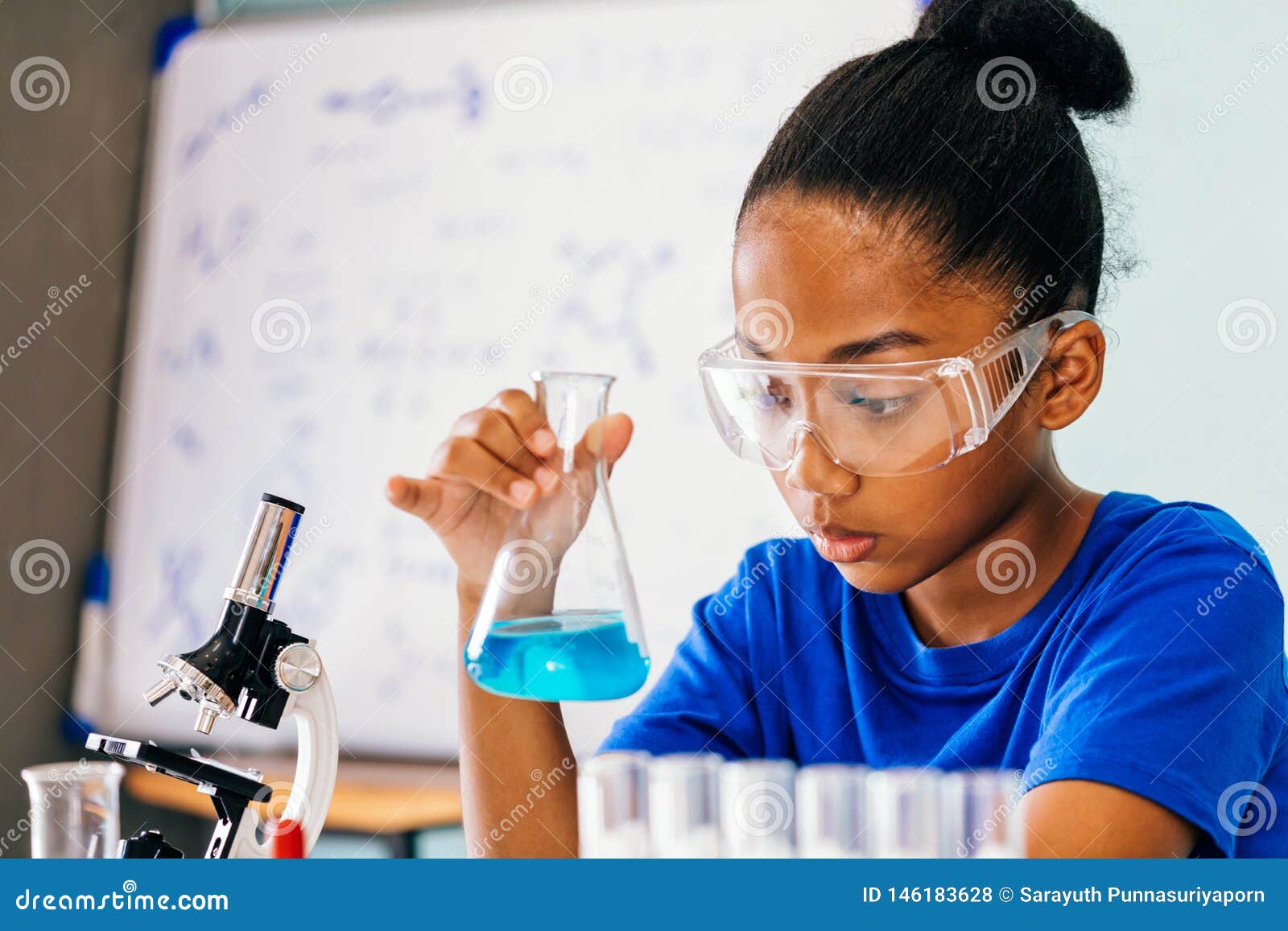 young african american kid doing chemistry experiment