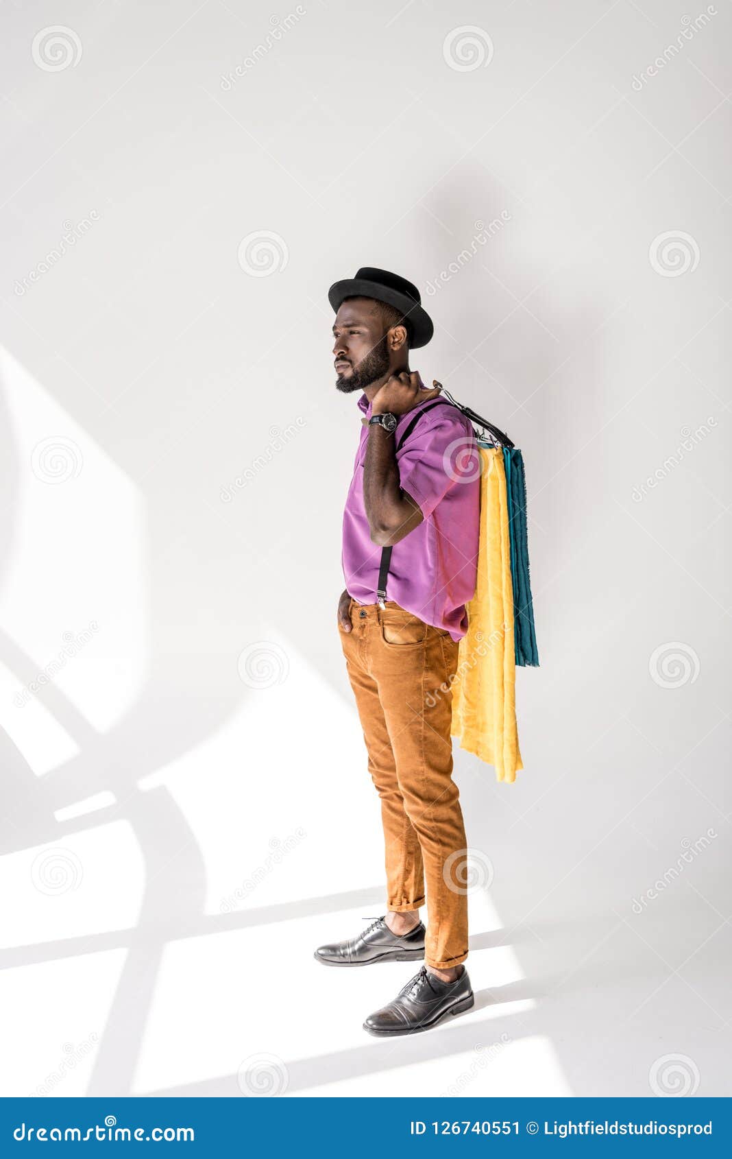 Young African American Man In Fashionable Clothing And Hat Holding ...