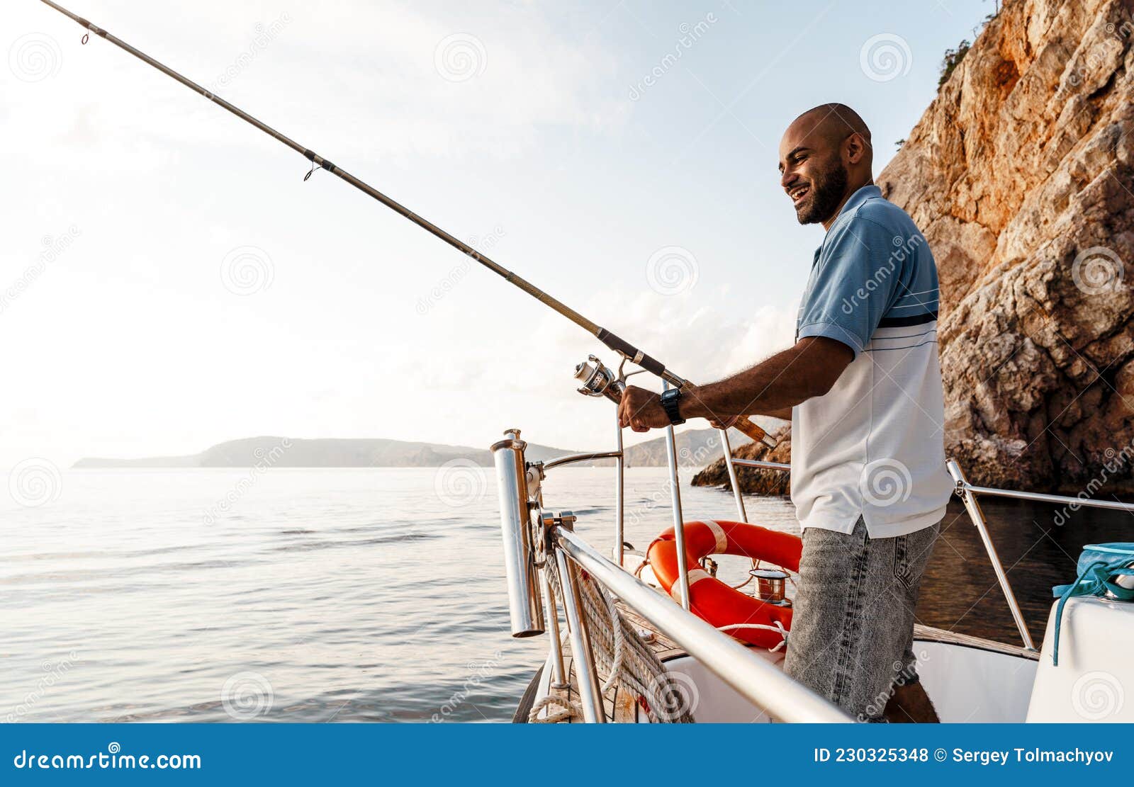 Young African American Man Standing with Fishing Rod on a Sailboat Fishing  in Open Sea on Sunset Stock Photo - Image of alone, ocean: 230325348