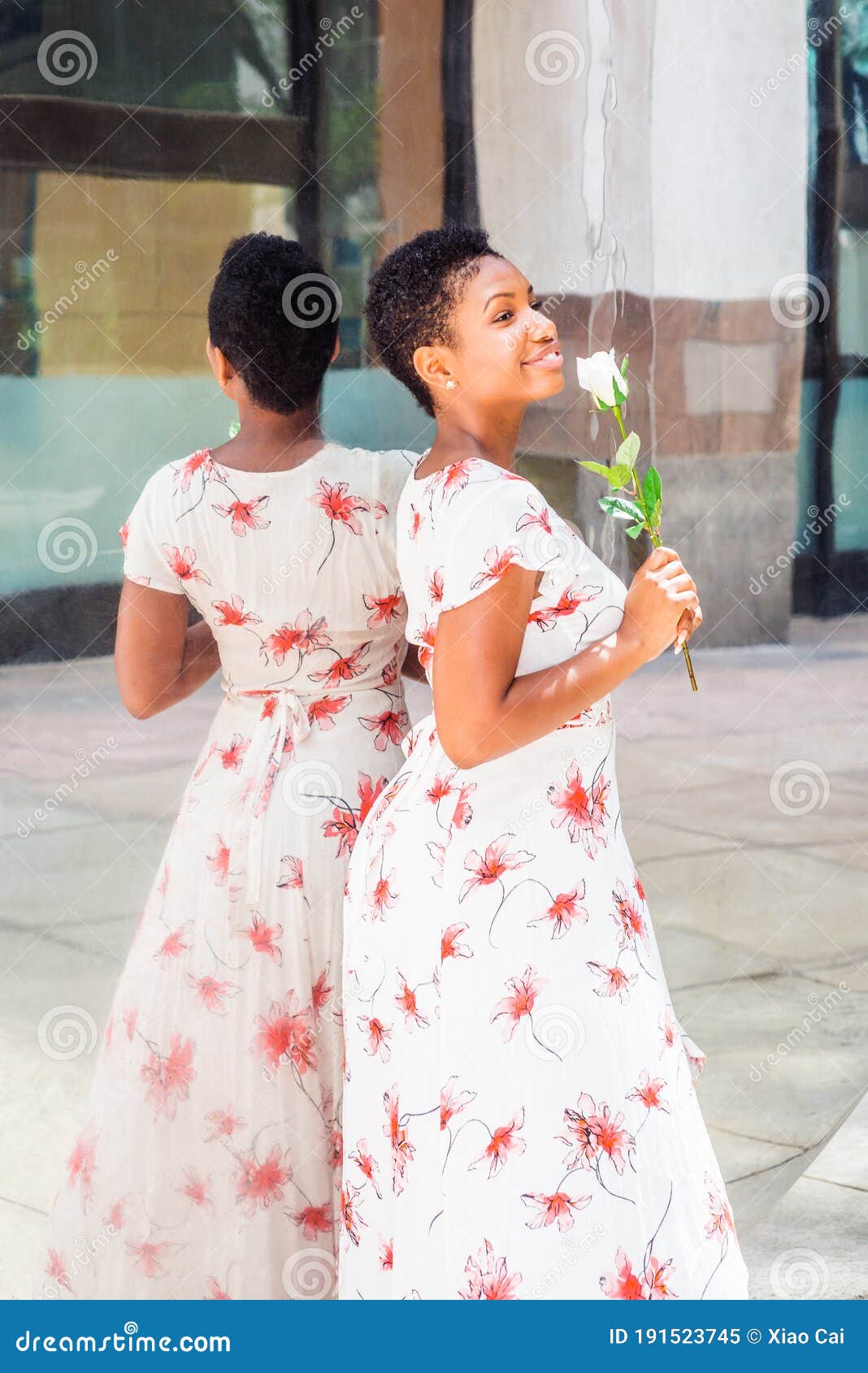 Young African American Woman Holding a White Rose, Standing by Mirror ...