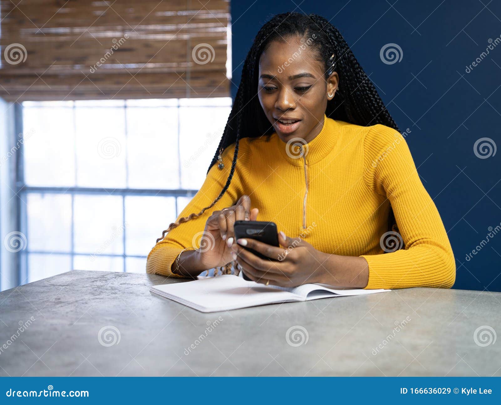 Young African American Woman with Yellow Shirt Sitting at the Kitchen ...