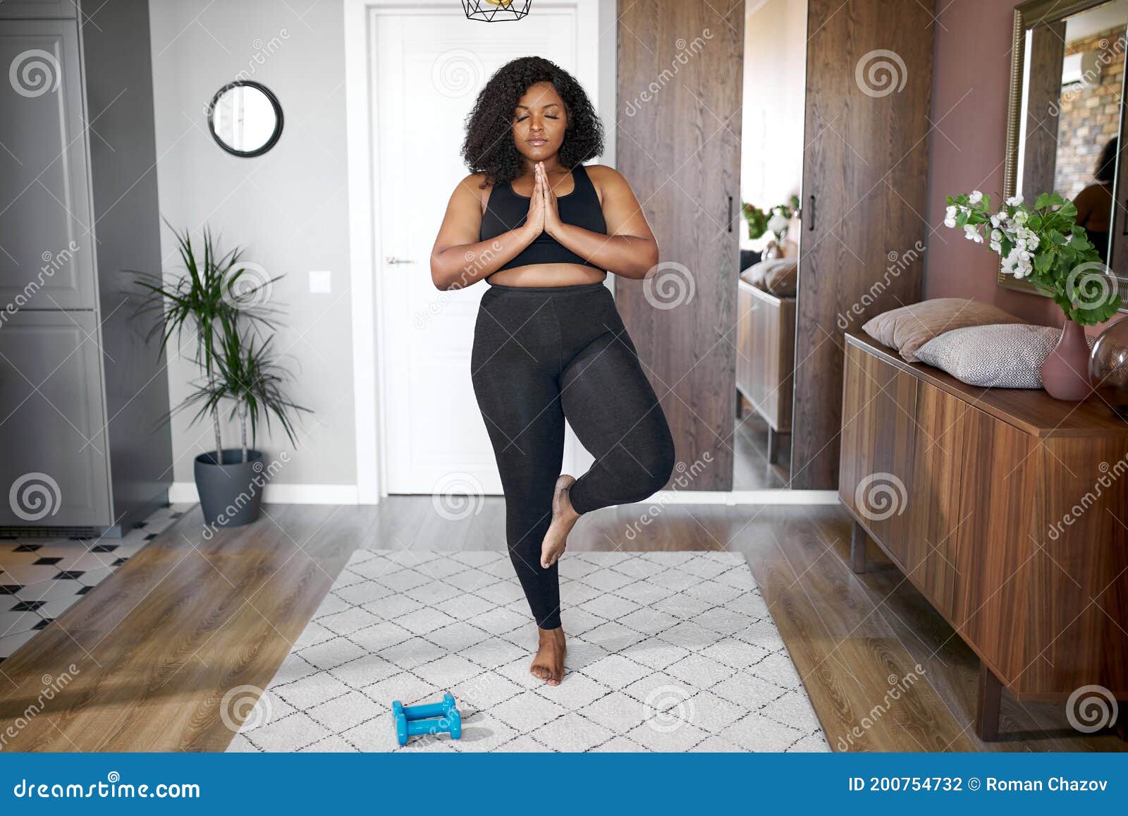 young african woman keep balance, stand on one leg, yoga time at home