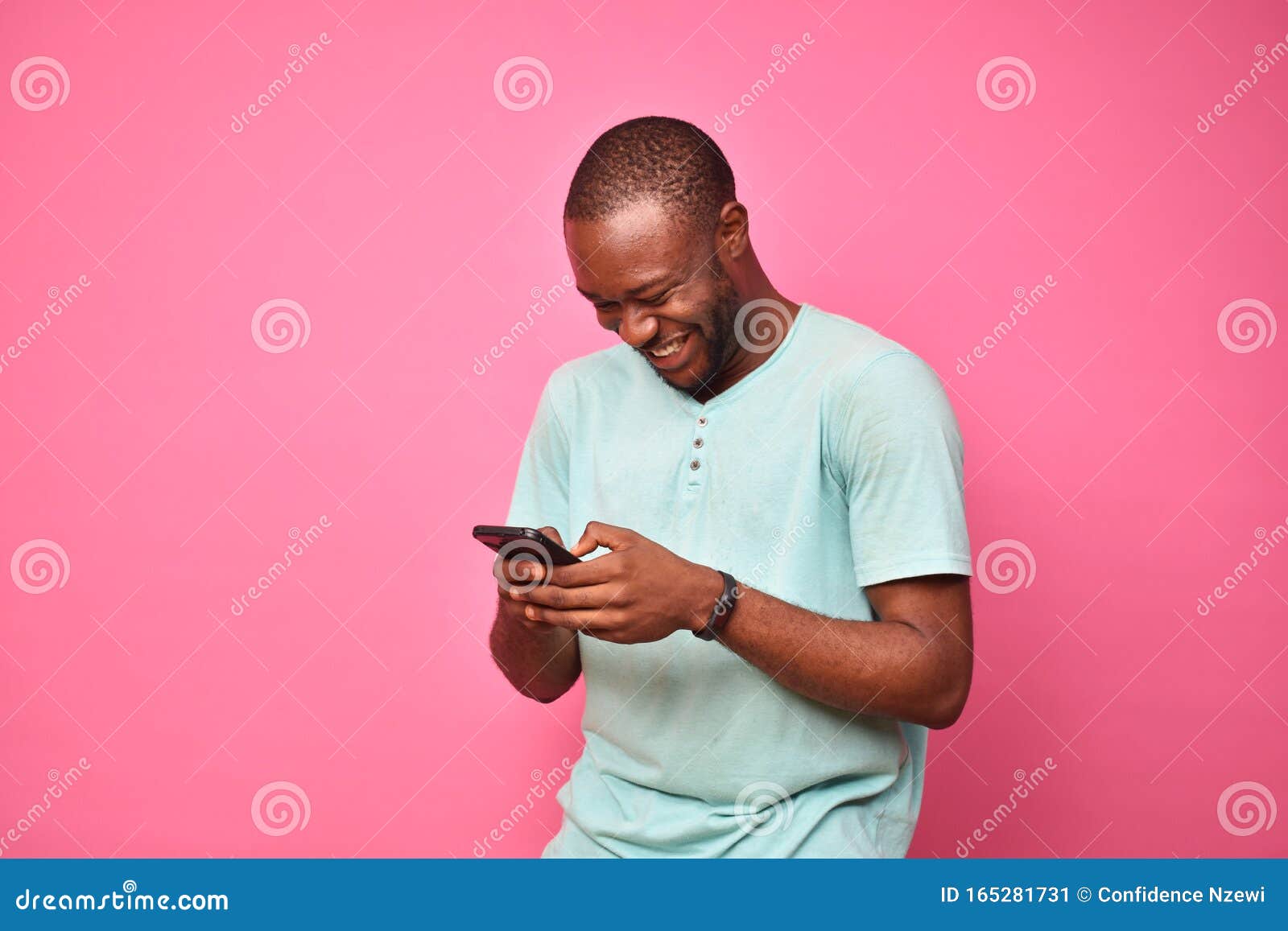 young african man looking very excited while using his cellphone