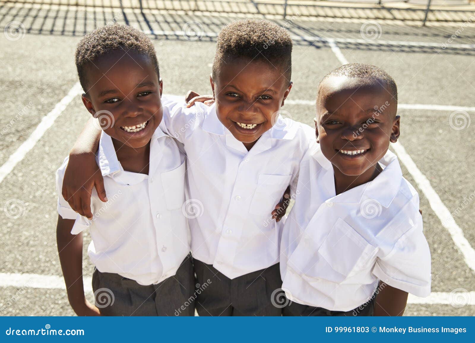 young african schoolboys smiling to camera in a playground