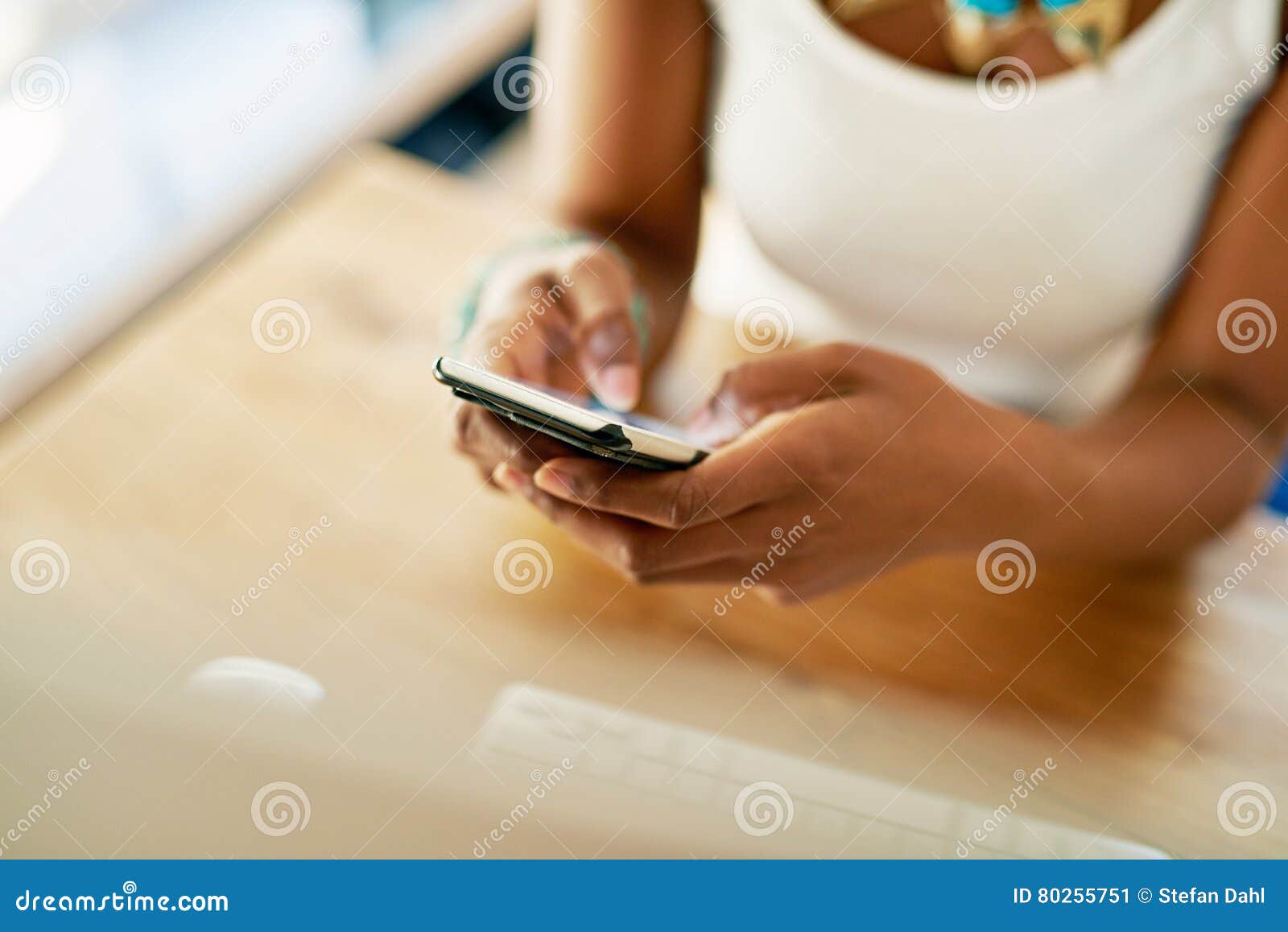 young african woman texting on her mobile