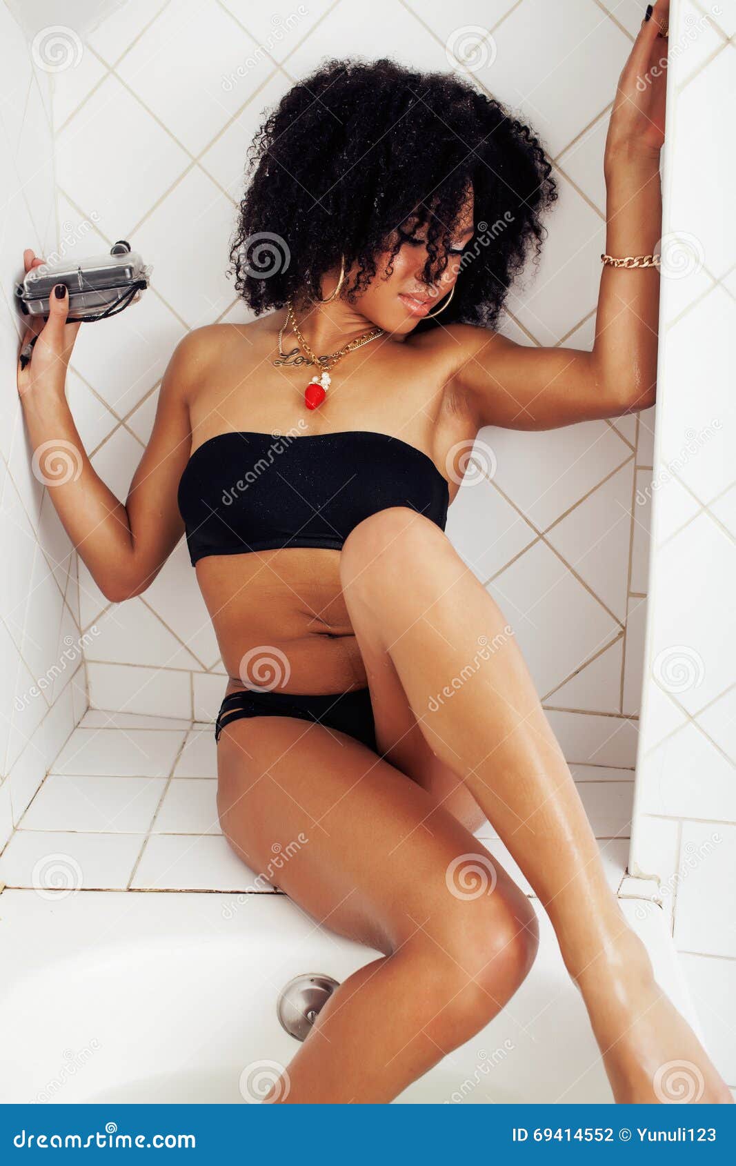 Young Afro-american Teen Girl Laying in Bath with Foam, Wearing Swag Jewelry Flawless, Making Selfie, Modern Lifestyle Stock Photo