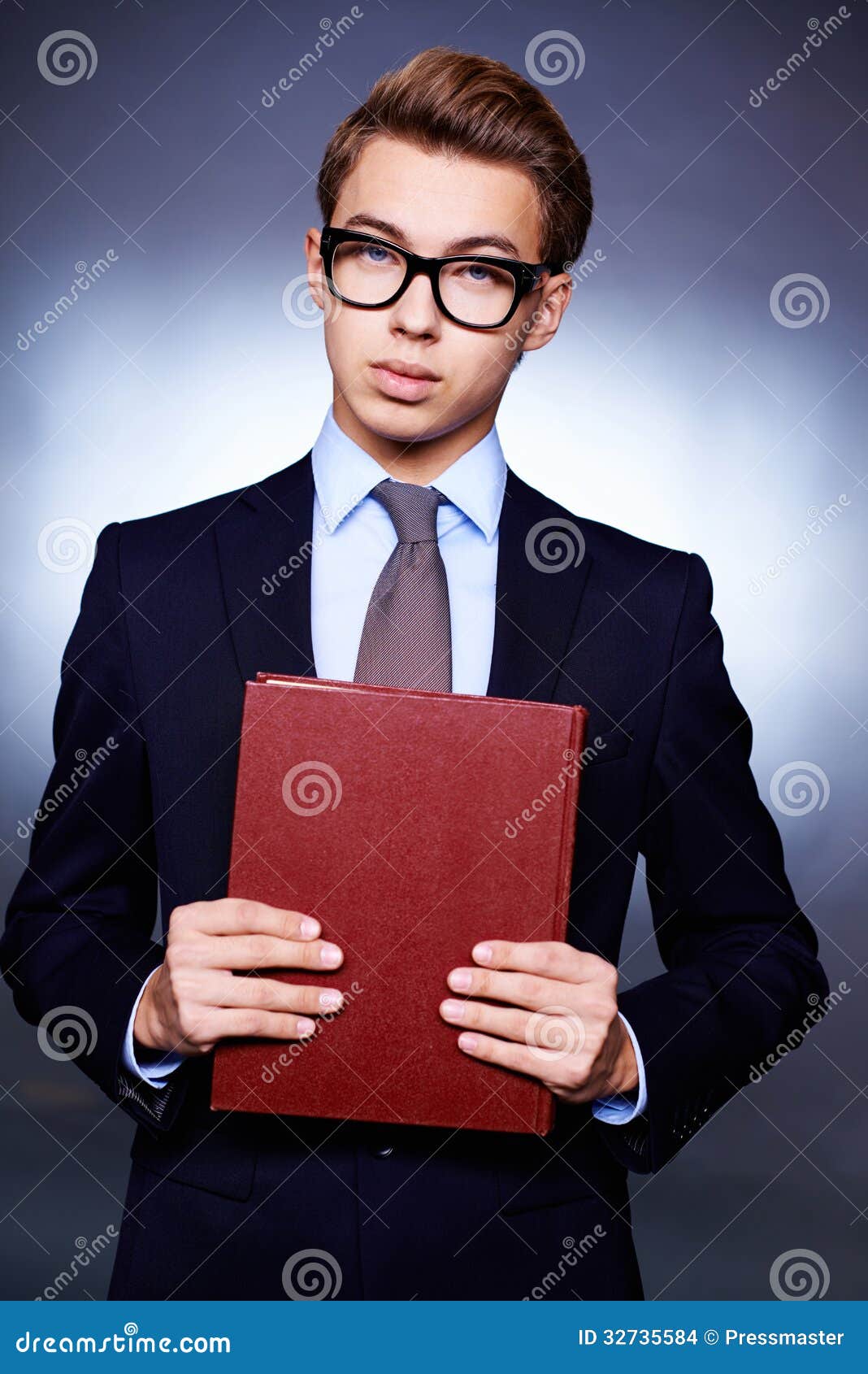 Young and ambitious. Vertical portrait of an ambitious young man dressed with elegance and holding a book