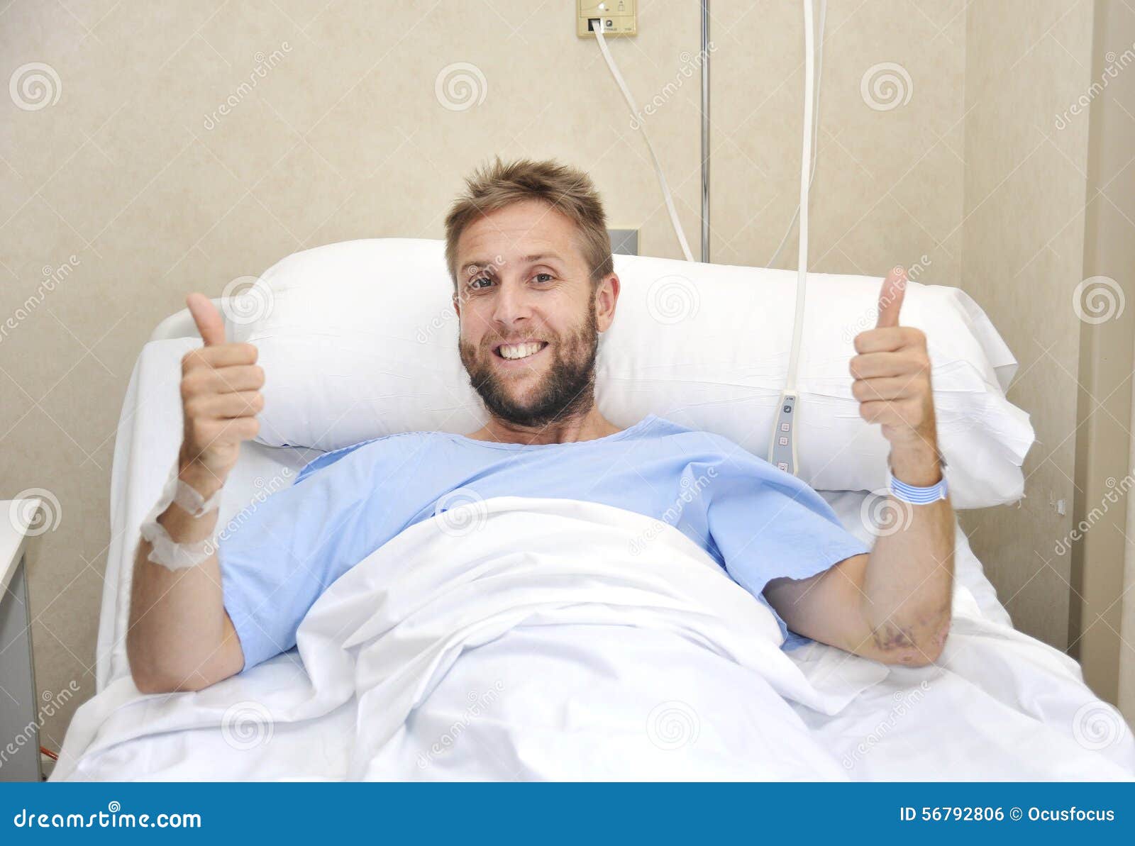 Young American Man Lying In Bed At Hospital Room Sick Or Ill But Giving ...