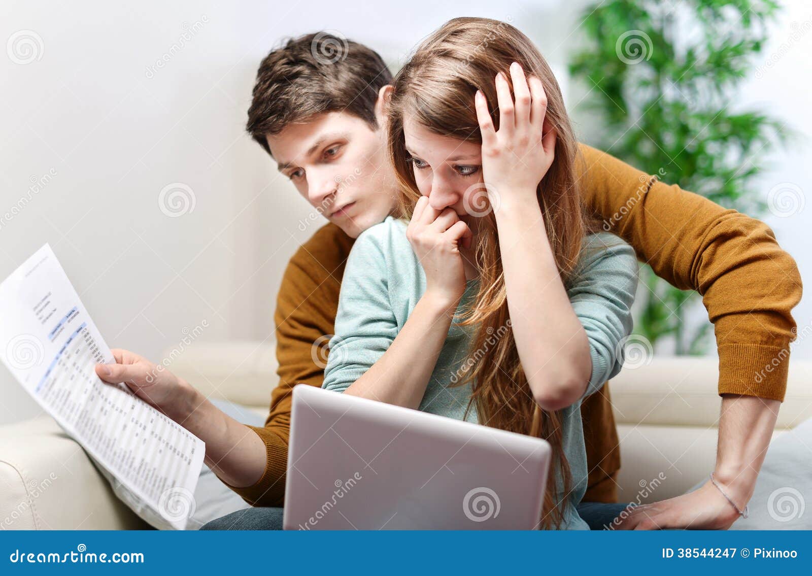 young anxious couple consults their bank account