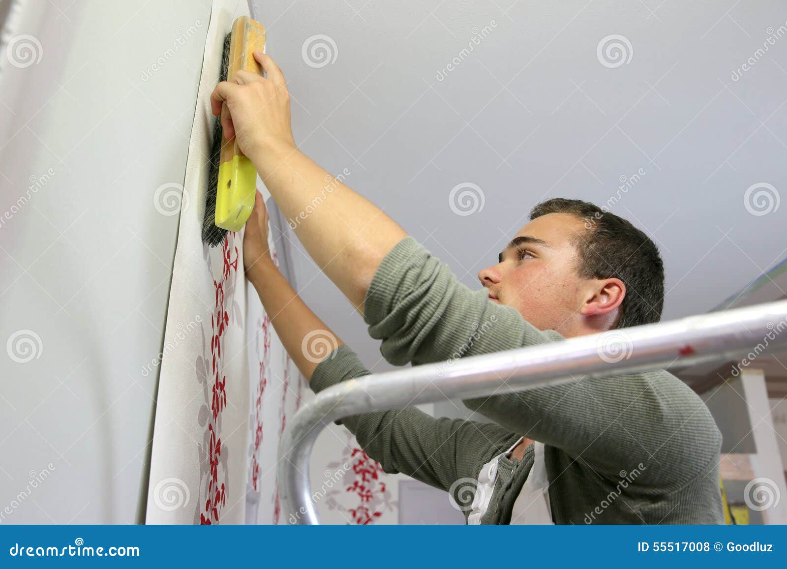 Young Apprentice Putting Wallpaper Stock Photo Image of putting
