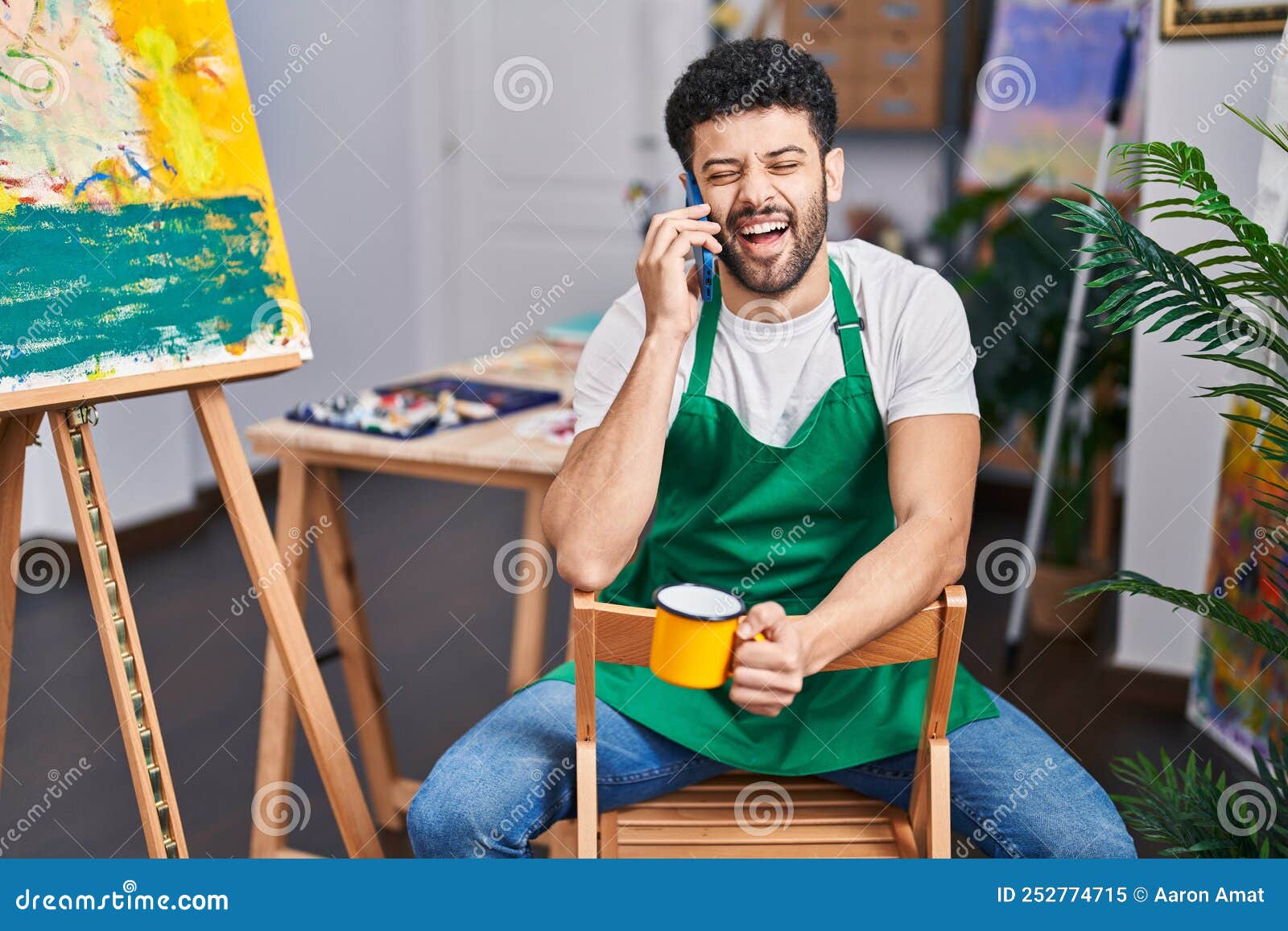 Young Arab Man Artist Talking on the Smartphone Drinking Coffee at Art