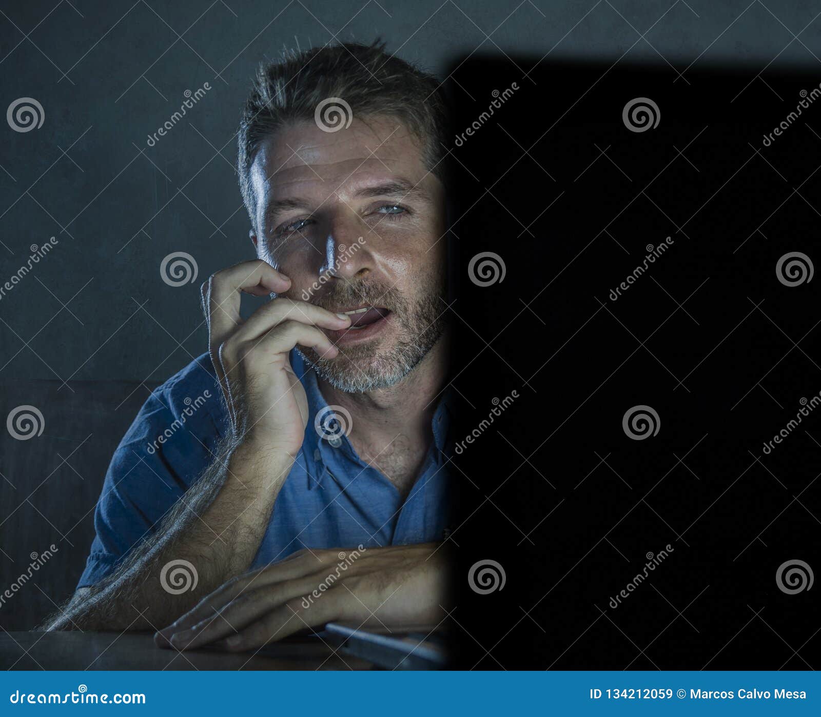 Young Aroused and Excited Sex Addict Man Watching Mobile Online in Laptop Computer Light Night at Home in Stock Image image pic