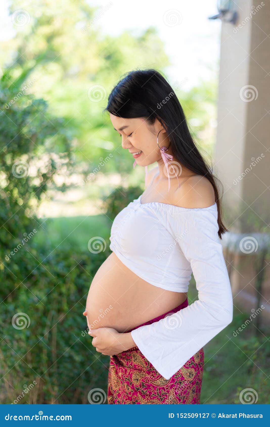 Young Asian Beautiful Pregnant Woman In White Dress Touching Her Belly