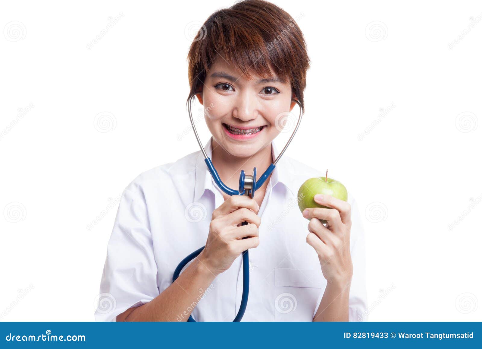 Young Asian female doctor listening to an apple with a stethoscope. Young Asian female doctor listening to an apple with a stethoscope isolated on white background.