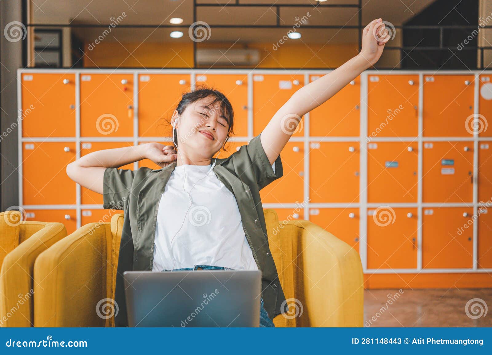 young asian freelancers are stretching oneself and relaxing after working and planning to work while working on laptop in the cafe
