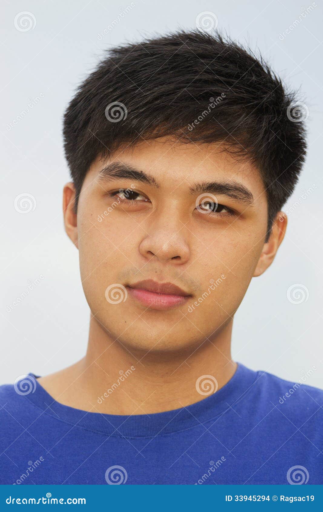 Portrait Of A Young Handsome Asian Man With Blue Eyes And Dark