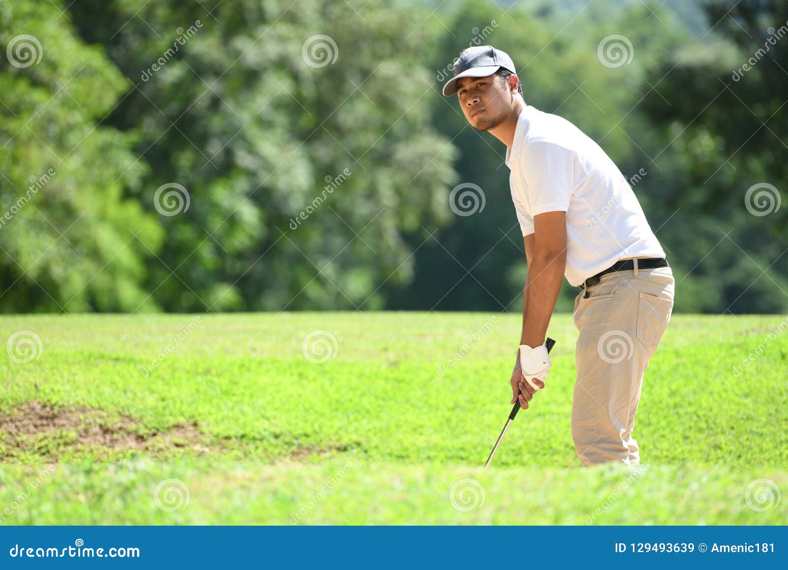 Young Asian Man Playing Golf on a Beautiful Natural Golf Course Stock