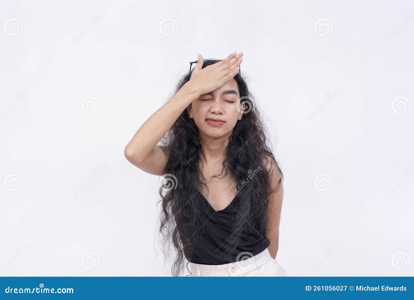 a young asian woman facepalms, realizing her mistake or forgetting something important. frustrated reaction from blunder or botch