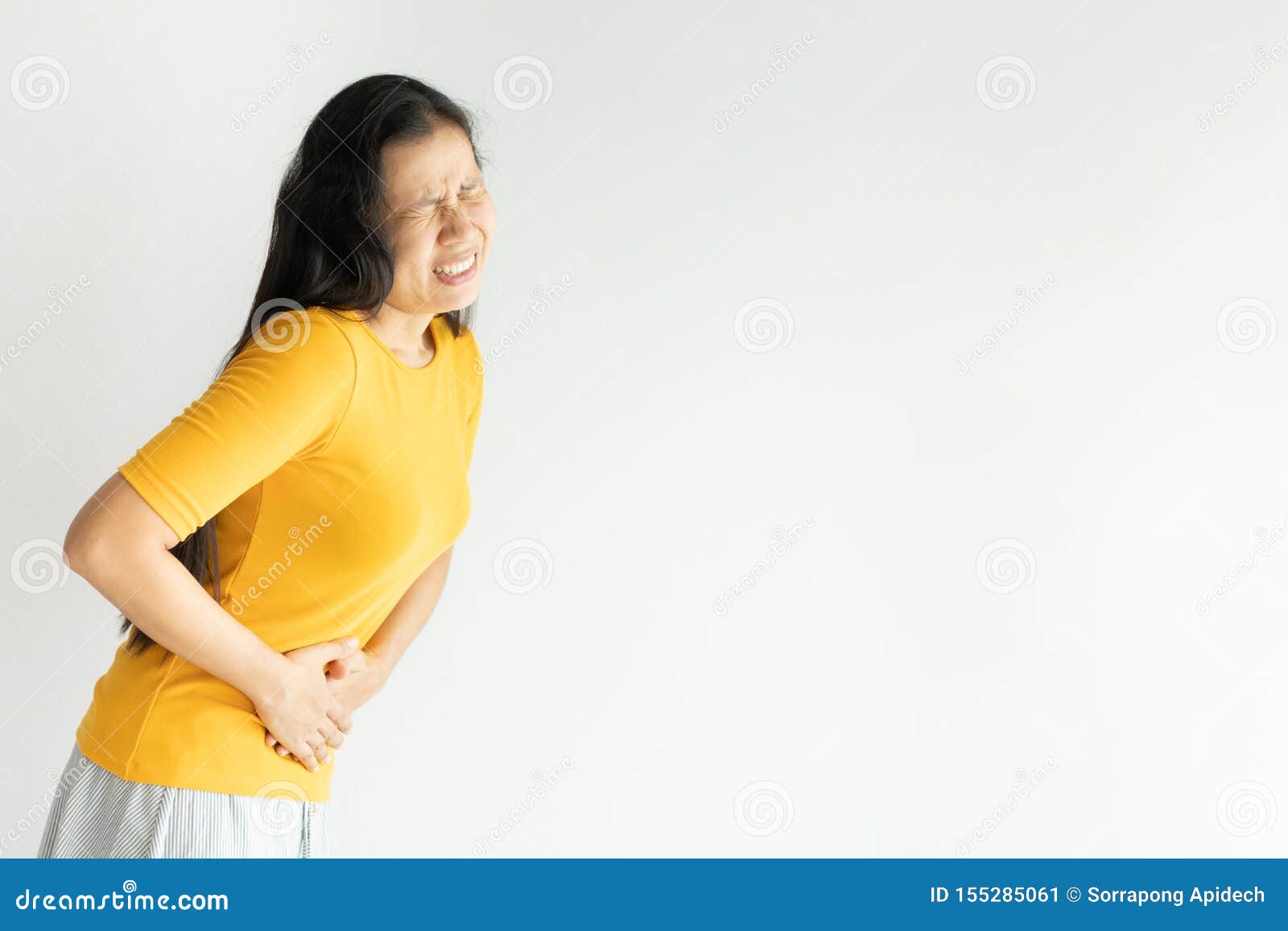 young asian woman having painful stomachache on white background.chronic gastritis. abdomen bloating concept