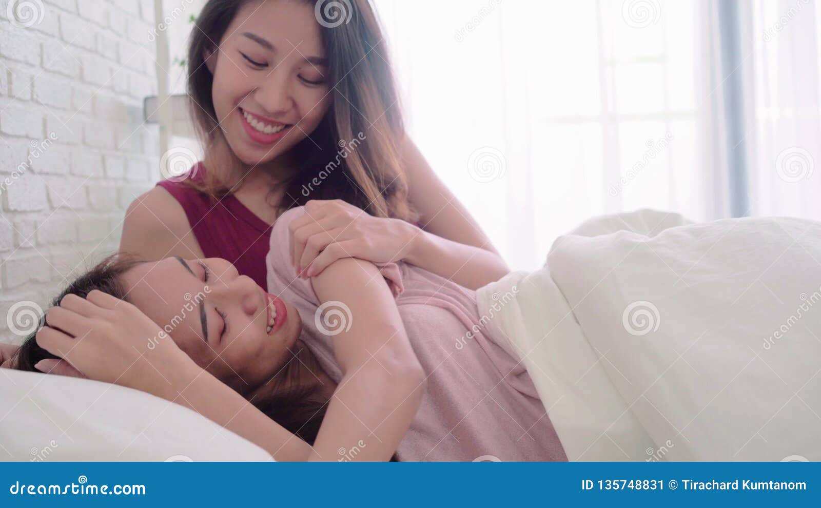 Young Asian Women Lesbian Happy Couple Waking Up in the Morning on Bed in Bedroom at Home