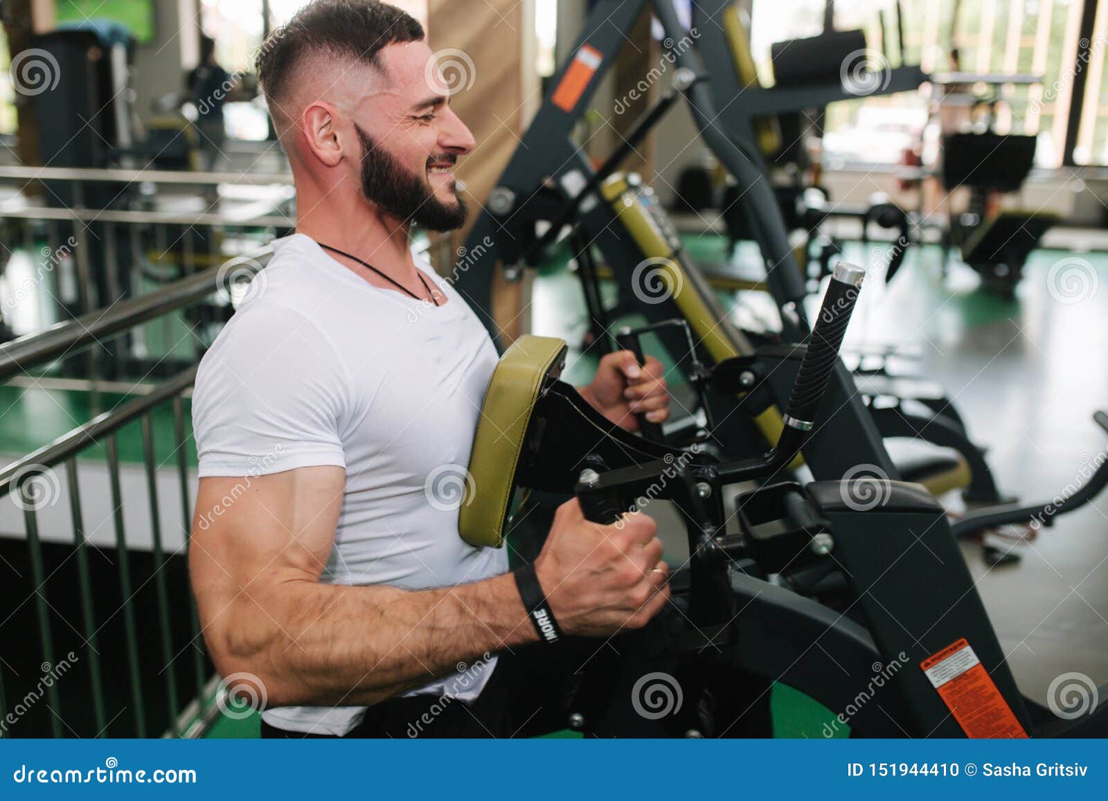 A Young Athlete Trains in the Gym. Bodybuilder Trains the Muscules of