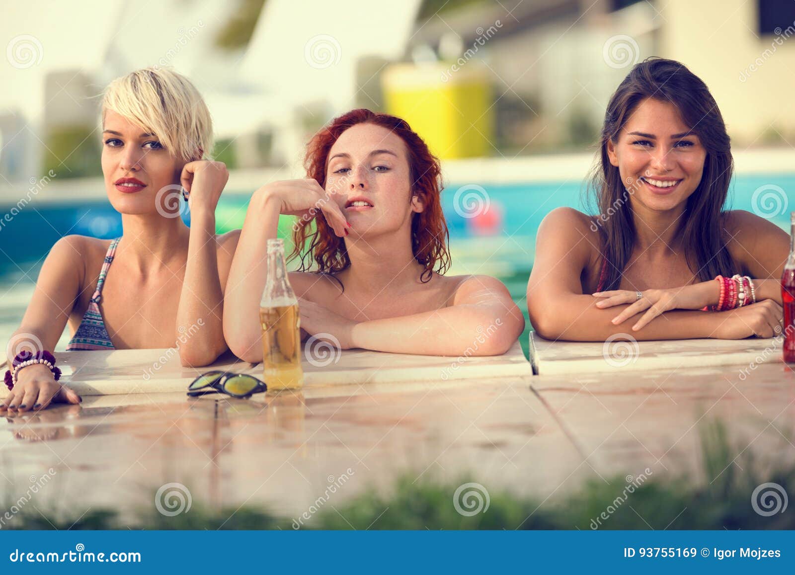 blond, brunette and red haired female bathers posing on edge of