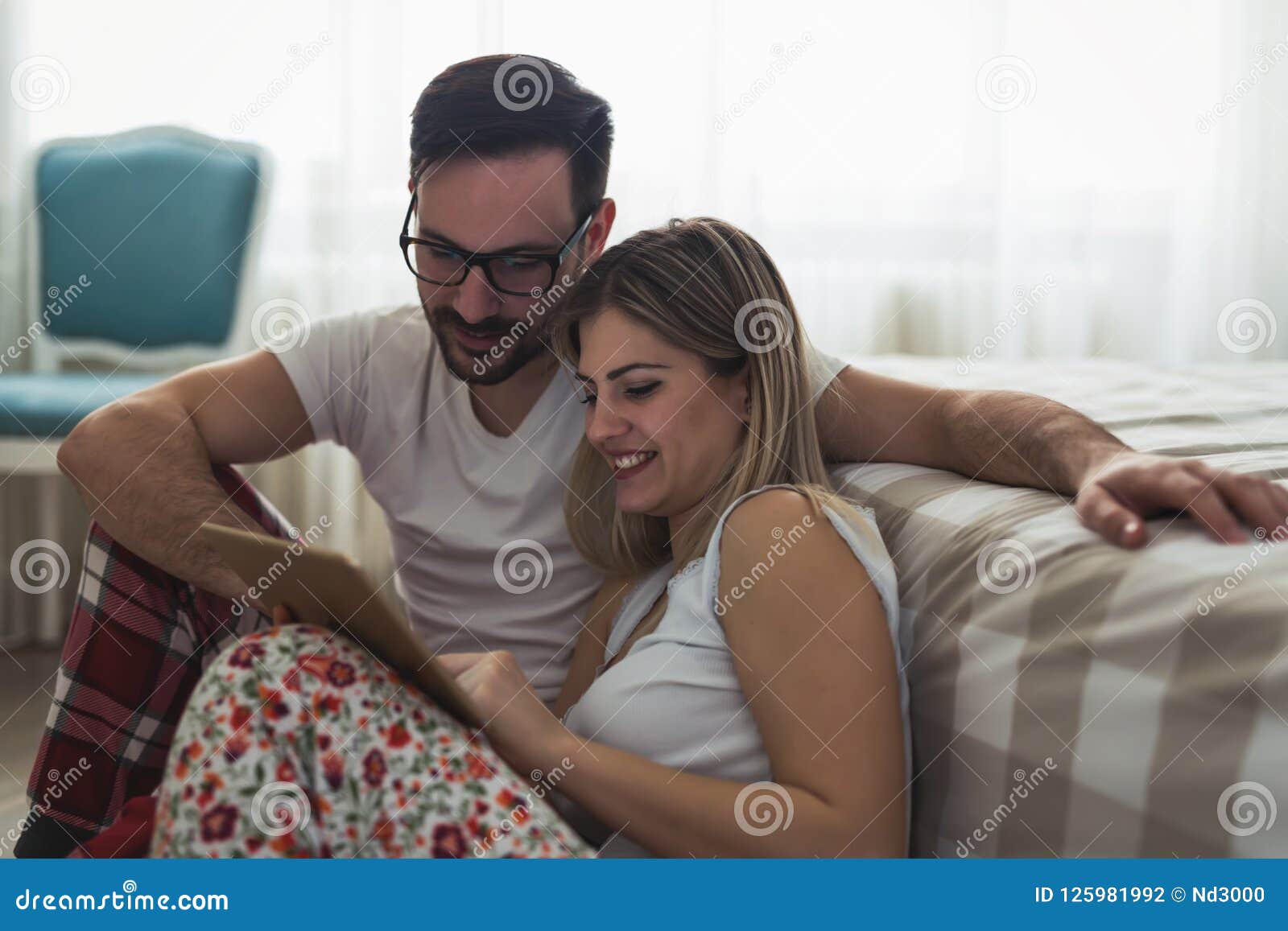 Young Attractive Couple Using Tablet In Bedroom St