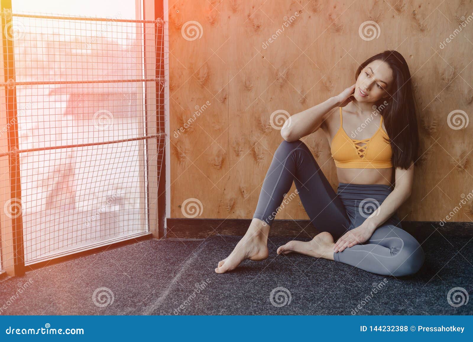 Young Attractive Fitness Girl Sitting On The Floor Near The Window On