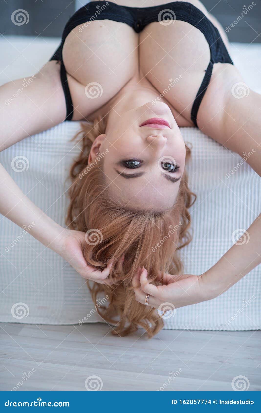 A Young Attractive Girl with Very Large Breasts in Underwear Lies on Her  Back and Straightens Her Hair on Her Head. Stock Photo - Image of boobs,  bedclothes: 162057774