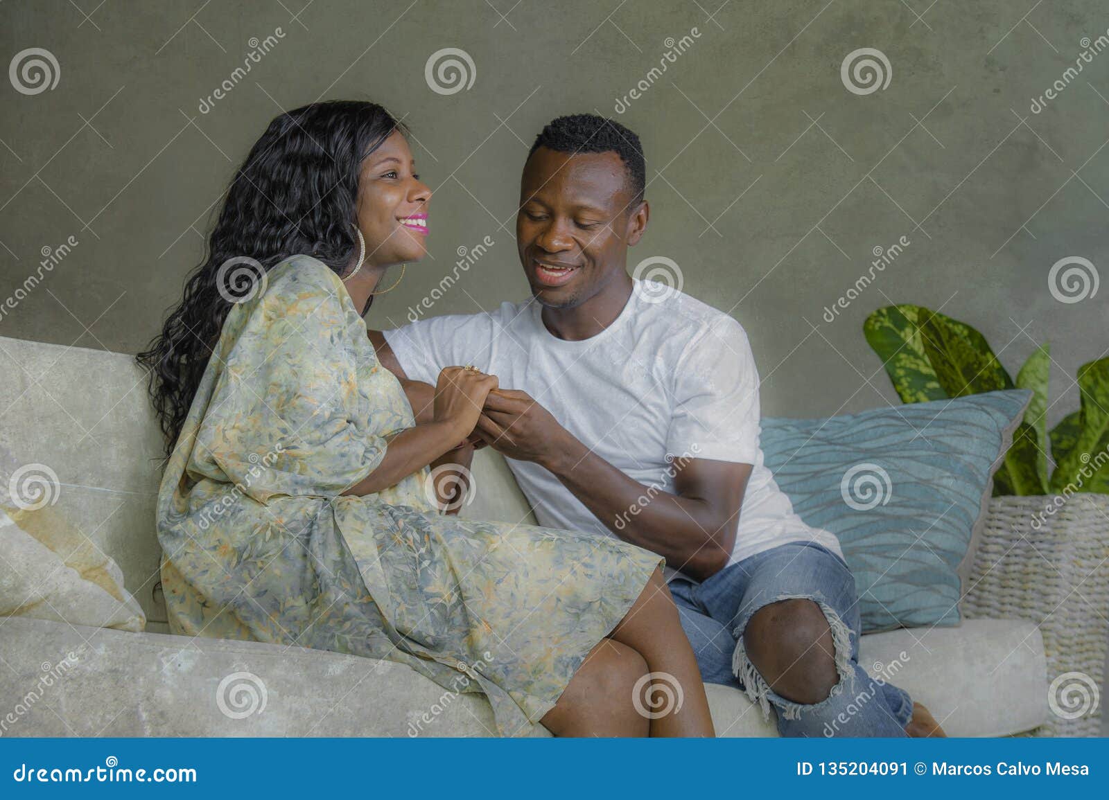 young attractive and happy black african american couple relaxed at home sofa couch talking sweet enjoying together and smiling in