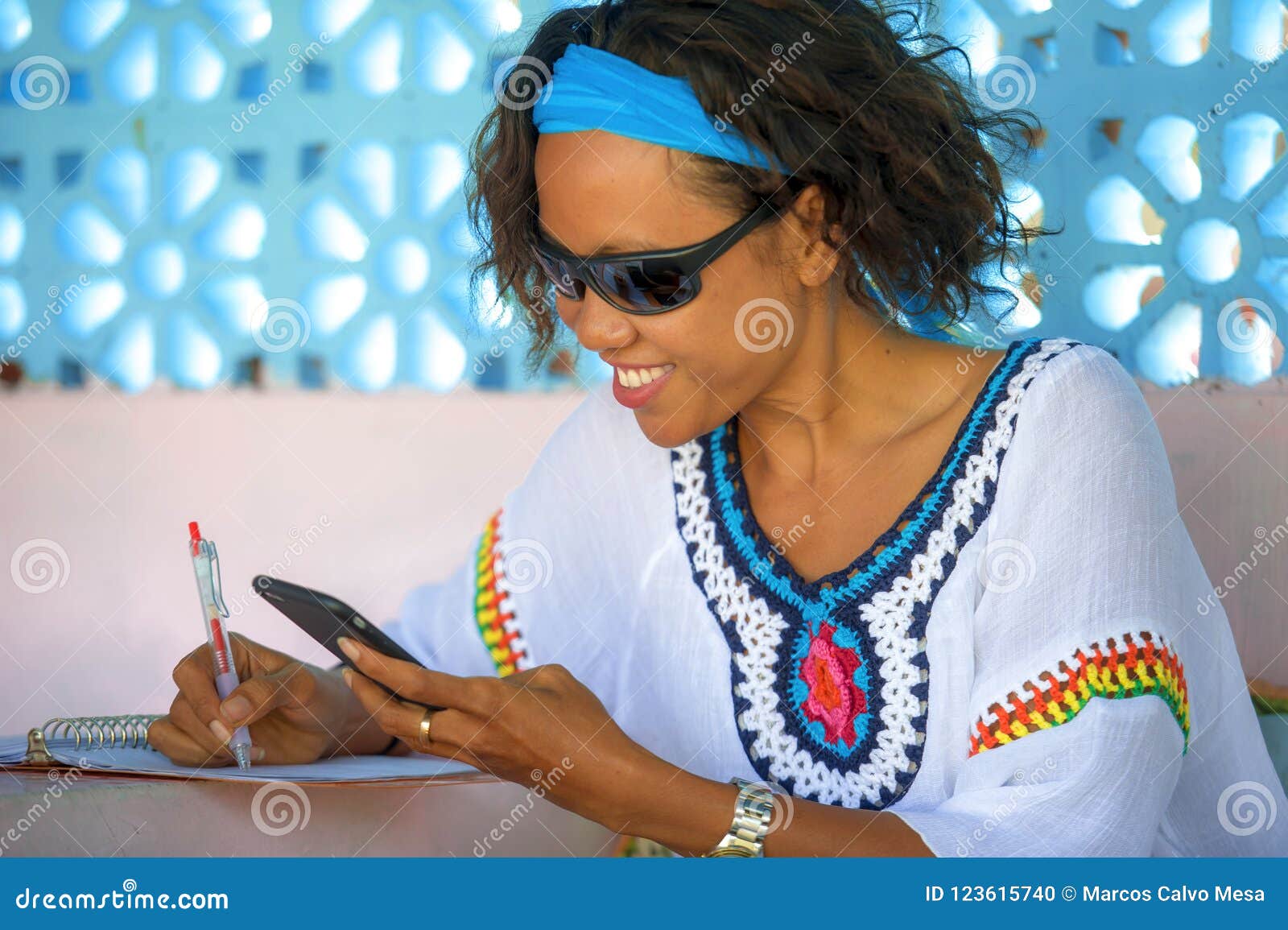 young attractive hipster and exotic looking girl happy and relaxed using internet social media working on mobile phone smiling tak